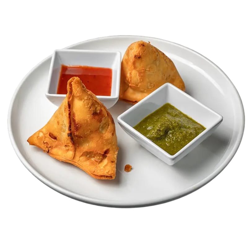 Two golden-brown samosas with red and green chutneys on a white plate.