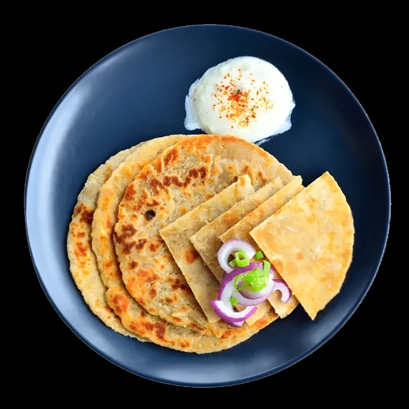 Indian paratha bread with a side of yogurt and sliced red onions on a dark blue plate.